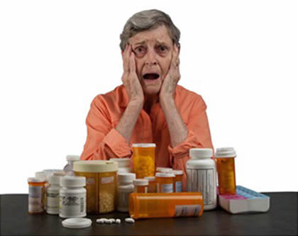 An elderly woman with a table full of medications looking overwhelmed and confused